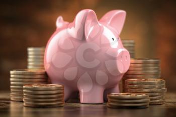Piggy bank and Stacks of olden coins. Concept of finance, savings and investitions. 3d illustration