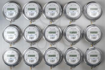 Digital electric meters in a row measuring power use. Electricity consumption concept. 3d illustration
