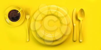 Top view of yellow plate, fork, knife, spoon and cup of coffee on yellow grunge table. 3d illustration