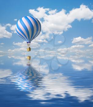 3d balloons in the blue sky and reflection in water