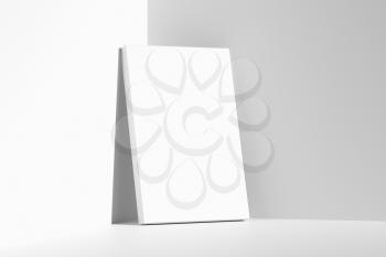 Blank white empty rectangular poster on floor leaning at empty white walls in cornet diagonal view, white bleached colorless poster mock-up, 3D Illustration