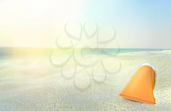 Beach scene with sunscreen against ocean background.