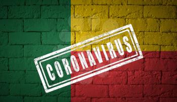 Flag of the Benin on brick wall texture. stamped of Coronavirus. Corona virus concept. On the verge of a COVID-19 or 2019-nCoV Pandemic.