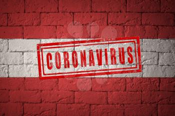 Flag of the Austria with original proportions. stamped of Coronavirus. brick wall texture. Corona virus concept. On the verge of a COVID-19 or 2019-nCoV Pandemic.