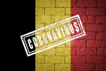 Flag of the Belgium with original proportions. stamped of Coronavirus. brick wall texture. Corona virus concept. On the verge of a COVID-19 or 2019-nCoV Pandemic.