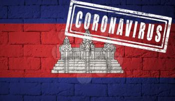 Flag of the Cambodia with original proportions. stamped of Coronavirus. brick wall texture. Corona virus concept. On the verge of a COVID-19 or 2019-nCoV Pandemic.