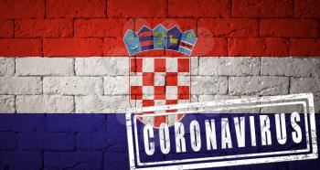 Flag of the Croatia with original proportions. stamped of Coronavirus. brick wall texture. Corona virus concept. On the verge of a COVID-19 or 2019-nCoV Pandemic.