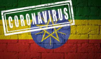 Flag of the Ethiopia on brick wall texture. stamped of Coronavirus. Corona virus concept. On the verge of a COVID-19 or 2019-nCoV Pandemic. Novel Chinese Coronavirus outbreak