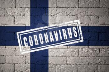 Flag of the Finland with original proportions. stamped of Coronavirus. brick wall texture. Corona virus concept. On the verge of a COVID-19 or 2019-nCoV Pandemic.