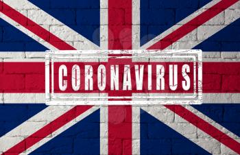 Flag of the United Kingdom or England with original proportions. stamped of Coronavirus. brick wall texture. Corona virus concept. On the verge of a COVID-19 or 2019-nCoV Pandemic.