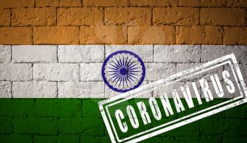 Flag of the India with original proportions. stamped of Coronavirus. brick wall texture. Corona virus concept. On the verge of a COVID-19 or 2019-nCoV Pandemic.