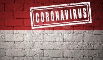 Flag of the Indonesia with original proportions. stamped of Coronavirus. brick wall texture. Corona virus concept. On the verge of a COVID-19 or 2019-nCoV Pandemic.