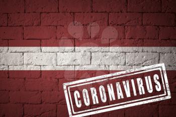 Flag of the Latvia with original proportions. stamped of Coronavirus. brick wall texture. Corona virus concept. On the verge of a COVID-19 or 2019-nCoV Pandemic.