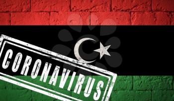 Flag of the Libya with original proportions. stamped of Coronavirus. brick wall texture. Corona virus concept. On the verge of a COVID-19 or 2019-nCoV Pandemic.