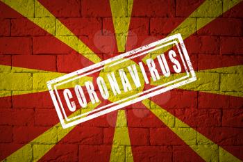 Flag of the North Macedonia with original proportions. stamped of Coronavirus. brick wall texture. Corona virus concept. On the verge of a COVID-19 or 2019-nCoV Pandemic.