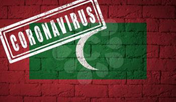 Flag of the Maldives on brick wall texture. stamped of Coronavirus. Corona virus concept. On the verge of a COVID-19 or 2019-nCoV Pandemic. Novel Chinese Coronavirus outbreak