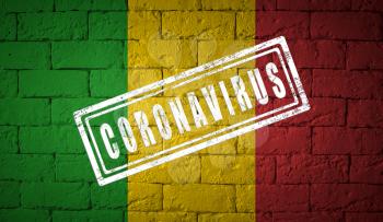 Flag of the Mali on brick wall texture. stamped of Coronavirus. Corona virus concept. On the verge of a COVID-19 or 2019-nCoV Pandemic. Novel Chinese Coronavirus outbreak