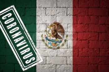 Flag of the Mexico with original proportions. stamped of Coronavirus. brick wall texture. Corona virus concept. On the verge of a COVID-19 or 2019-nCoV Pandemic.