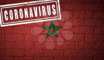 Flag of the Morocco with original proportions. stamped of Coronavirus. brick wall texture. Corona virus concept. On the verge of a COVID-19 or 2019-nCoV Pandemic.