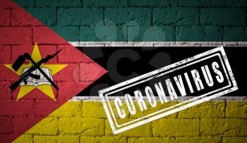 Flag of the Mozambique on brick wall texture. stamped of Coronavirus. Corona virus concept. On the verge of a COVID-19 or 2019-nCoV Pandemic. Novel Chinese Coronavirus outbreak