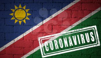 Flag of the Namibia on brick wall texture. stamped of Coronavirus. Corona virus concept. On the verge of a COVID-19 or 2019-nCoV Pandemic. Novel Chinese Coronavirus outbreak