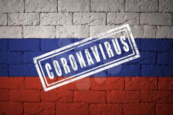 Flag of the Russia with original proportions. stamped of Coronavirus. brick wall texture. Corona virus concept. On the verge of a COVID-19 or 2019-nCoV Pandemic.