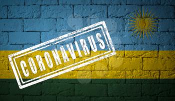 Flag of the Rwanda on brick wall texture. stamped of Coronavirus. Corona virus concept. On the verge of a COVID-19 or 2019-nCoV Pandemic. Novel Chinese Coronavirus outbreak