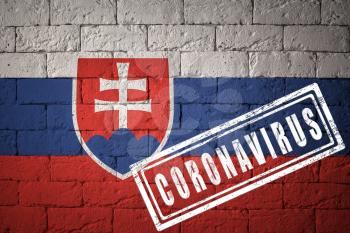 Flag of the Slovakia with original proportions. stamped of Coronavirus. brick wall texture. Corona virus concept. On the verge of a COVID-19 or 2019-nCoV Pandemic.