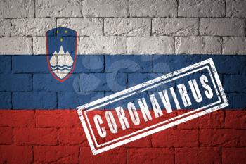 Flag of the Slovenia with original proportions. stamped of Coronavirus. brick wall texture. Corona virus concept. On the verge of a COVID-19 or 2019-nCoV Pandemic.