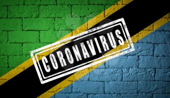 Flag of the Tanzania with original proportions. stamped of Coronavirus. brick wall texture. Corona virus concept. On the verge of a COVID-19 or 2019-nCoV Pandemic.