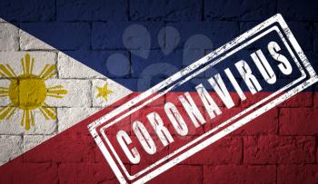Flag of the Philippines with original proportions. stamped of Coronavirus. brick wall texture. Corona virus concept. On the verge of a COVID-19 or 2019-nCoV Pandemic.