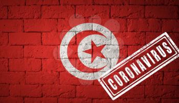 Flag of the Tunisia with original proportions. stamped of Coronavirus. brick wall texture. Corona virus concept. On the verge of a COVID-19 or 2019-nCoV Pandemic.