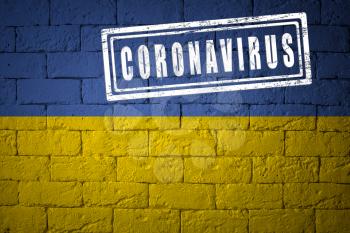 Flag of the Ukraine with original proportions. stamped of Coronavirus. brick wall texture. Corona virus concept. On the verge of a COVID-19 or 2019-nCoV Pandemic.