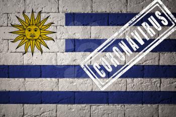 Flag of the Uruguay with original proportions. stamped of Coronavirus. brick wall texture. Corona virus concept. On the verge of a COVID-19 or 2019-nCoV Pandemic.