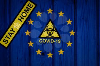 flag of European Union in original proportions. Quarantine and isolation - Stay at home. flag with biohazard symbol and inscription COVID-19.