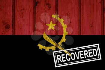 flag of Angola that survived or recovered from the infections of corona virus epidemic or coronavirus. Grunge flag with stamp Recovered