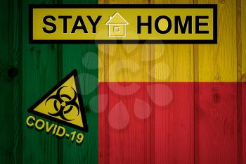 Flag of the Benin in original proportions. Quarantine and isolation - Stay at home. flag with biohazard symbol and inscription COVID-19.