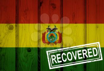 flag of Bolivia that survived or recovered from the infections of corona virus epidemic or coronavirus. Grunge flag with stamp Recovered