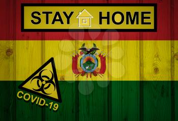 Flag of the Bolivia in original proportions. Quarantine and isolation - Stay at home. flag with biohazard symbol and inscription COVID-19.