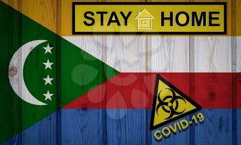 Flag of the Comoros in original proportions. Quarantine and isolation - Stay at home. flag with biohazard symbol and inscription COVID-19.