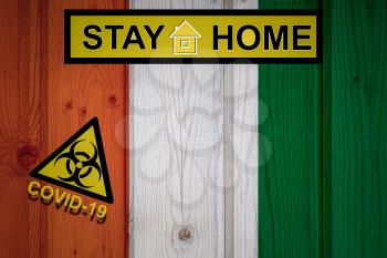 Flag of the Cote d'Ivoirein in original proportions. Quarantine and isolation - Stay at home. flag with biohazard symbol and inscription COVID-19.