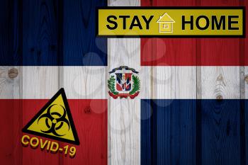 Flag of the Dominican Republic in original proportions. Quarantine and isolation - Stay at home. flag with biohazard symbol and inscription COVID-19.