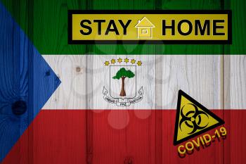 Flag of the Equatorial Guinea in original proportions. Quarantine and isolation - Stay at home. flag with biohazard symbol and inscription COVID-19.
