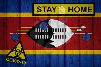 Flag of the Eswatini in original proportions. Quarantine and isolation - Stay at home. flag with biohazard symbol and inscription COVID-19.