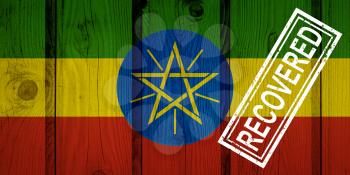 flag of Ethiopia that survived or recovered from the infections of corona virus epidemic or coronavirus. Grunge flag with stamp Recovered