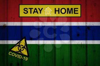 Flag of the Gambia in original proportions. Quarantine and isolation - Stay at home. flag with biohazard symbol and inscription COVID-19.