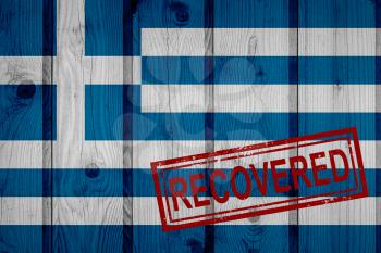 flag of Greece that survived or recovered from the infections of corona virus epidemic or coronavirus. Grunge flag with stamp Recovered