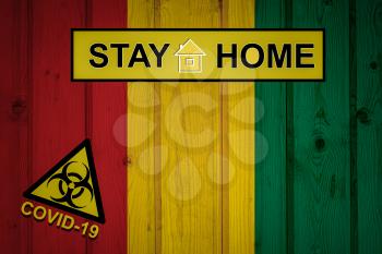 Flag of the Guinea in original proportions. Quarantine and isolation - Stay at home. flag with biohazard symbol and inscription COVID-19.