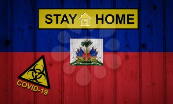 Flag of the Haiti in original proportions. Quarantine and isolation - Stay at home. flag with biohazard symbol and inscription COVID-19.