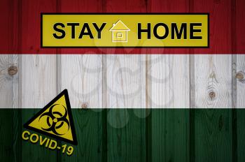 Flag of the Hungary in original proportions. Quarantine and isolation - Stay at home. flag with biohazard symbol and inscription COVID-19.